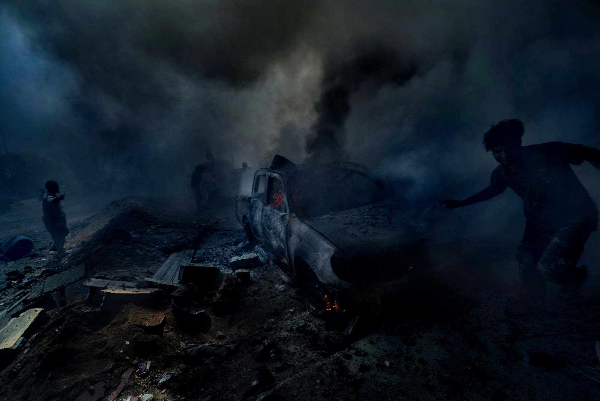 Sirte, Lybia, August 2016. People try to put out the fire left from a suicide car bomb that is said to have killed numerous fighters and left 60 wounded during an offensive. Ricardo Garcia Vilanova / ICRC