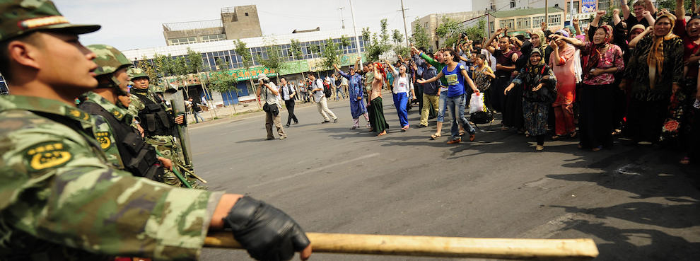 Ethnic Uyghur women protest towards Chinese riot police in Urumqi in China's far west Xinjiang province on July 7, 2009. (PETER PARKS/AFP/Getty Images)
