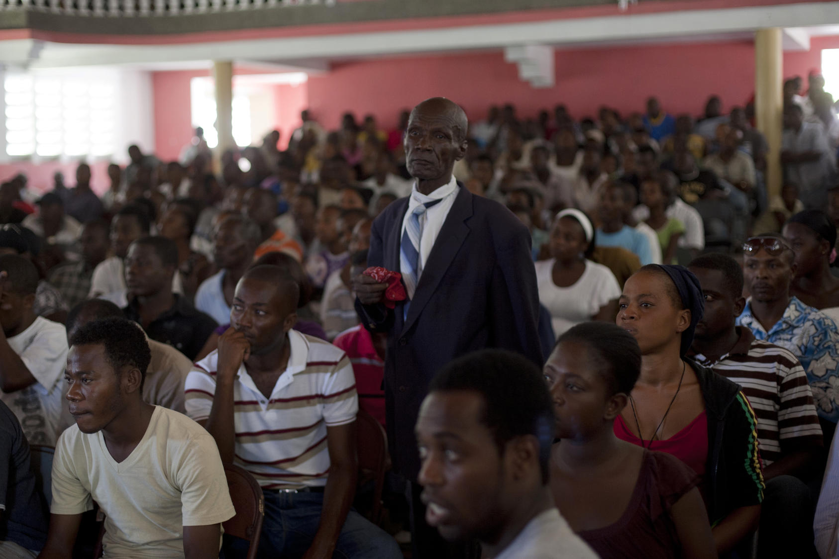Audience of a courtroom during a trial of police officers, who are charged with murder or attempted murder for a prison massacre, at the Catholic Cultural Center Saint-Louis in Haiti, Oct. 2011. Photo Courtesy of The New York Times/Andres Martinez Casares