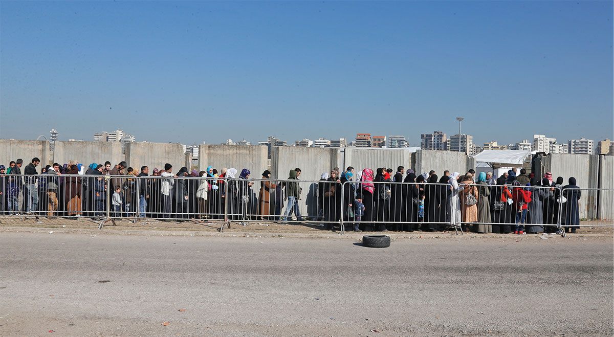 Syrian refugees line up to register with the UNHCR in Tripoli, Lebanon.
