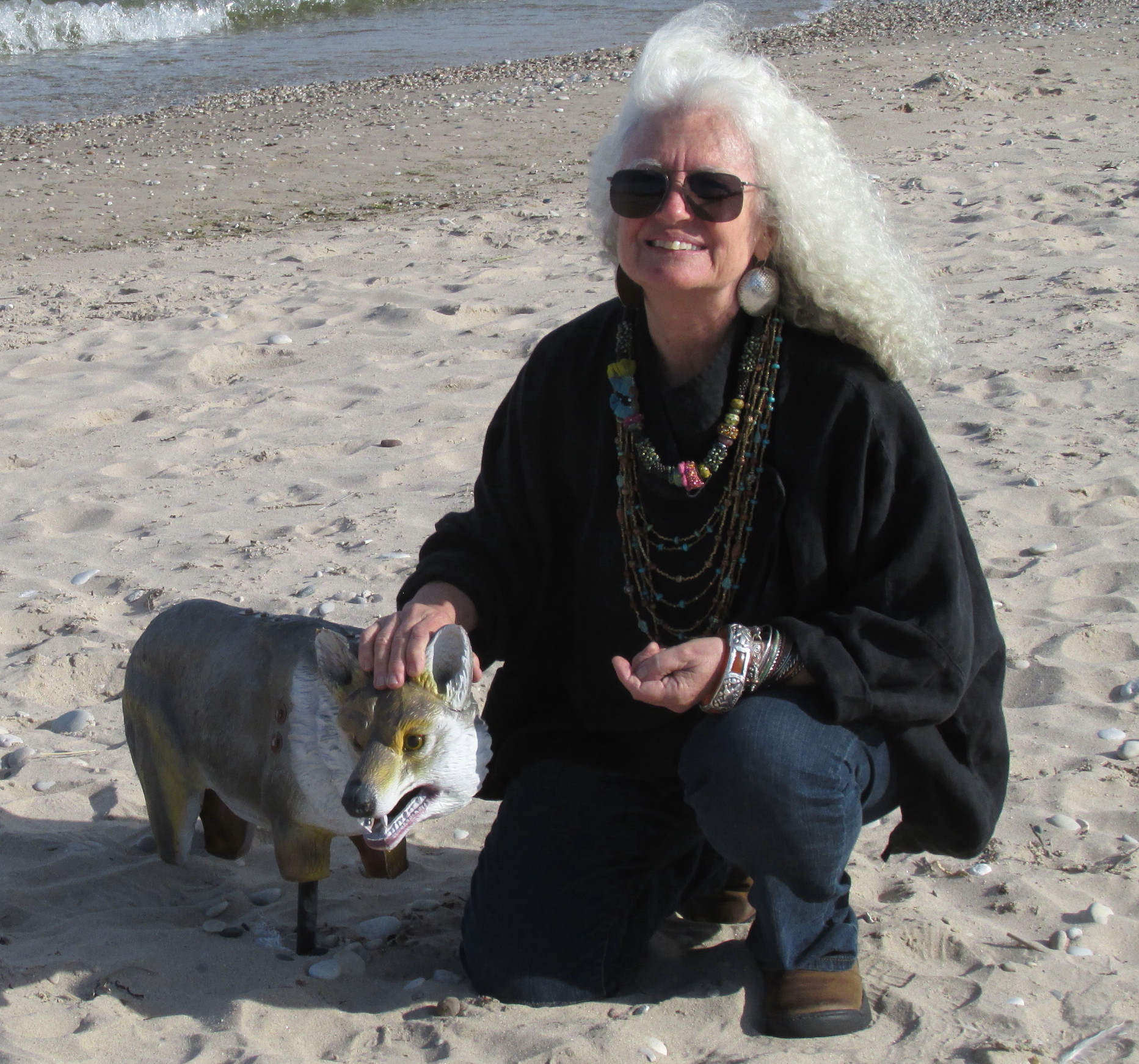 Judie on the beach visiting with one of the rubber foxes that inhabit the sand to help keep away the birds.