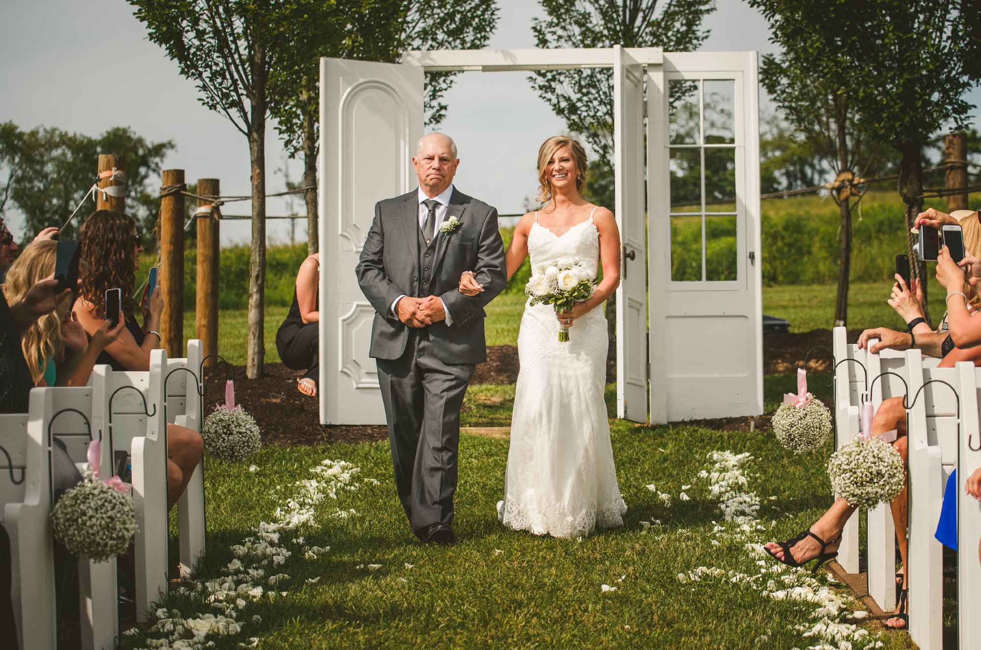 Bride and father walking down aisle at wedding ceremony