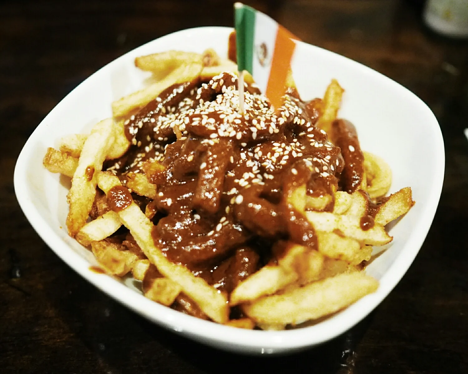 mission fig mole fries: house made fries topped with mission fig mole poblano sauce and sesame seeds.