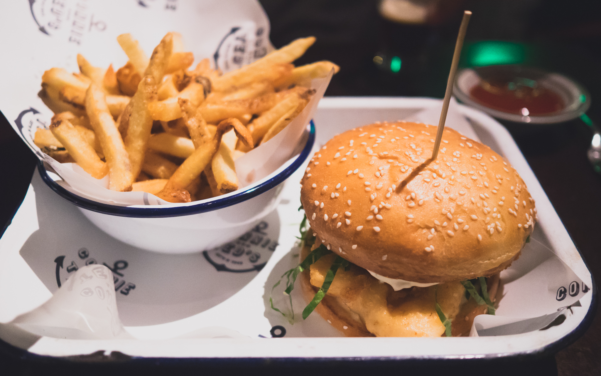 beer dipped cod sandwich with shredded lettuce and pickles, side of fries.