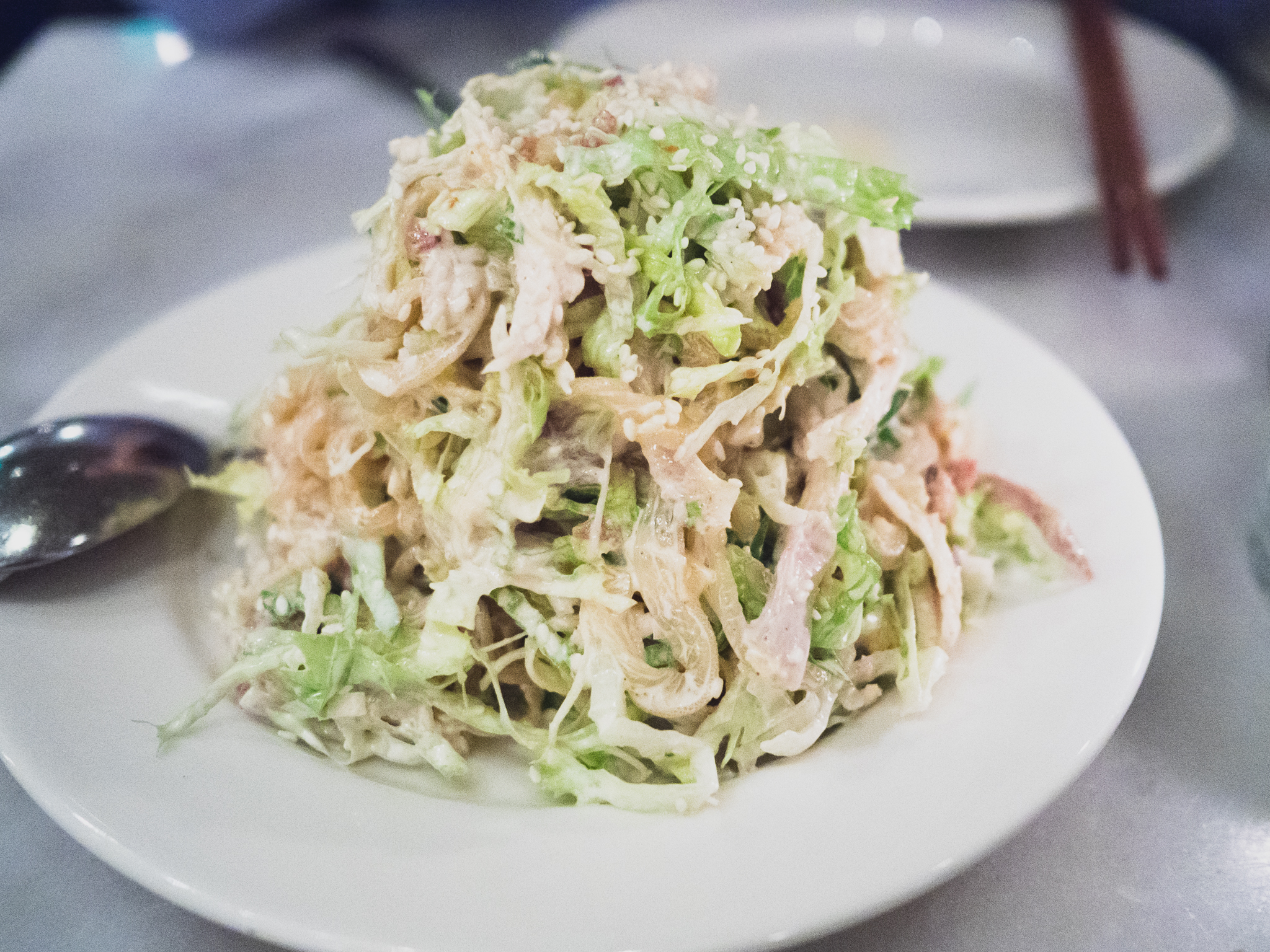 jellyfish salad with shredded chicken, crispy rice, green leaf, sesame bacon dressing.
