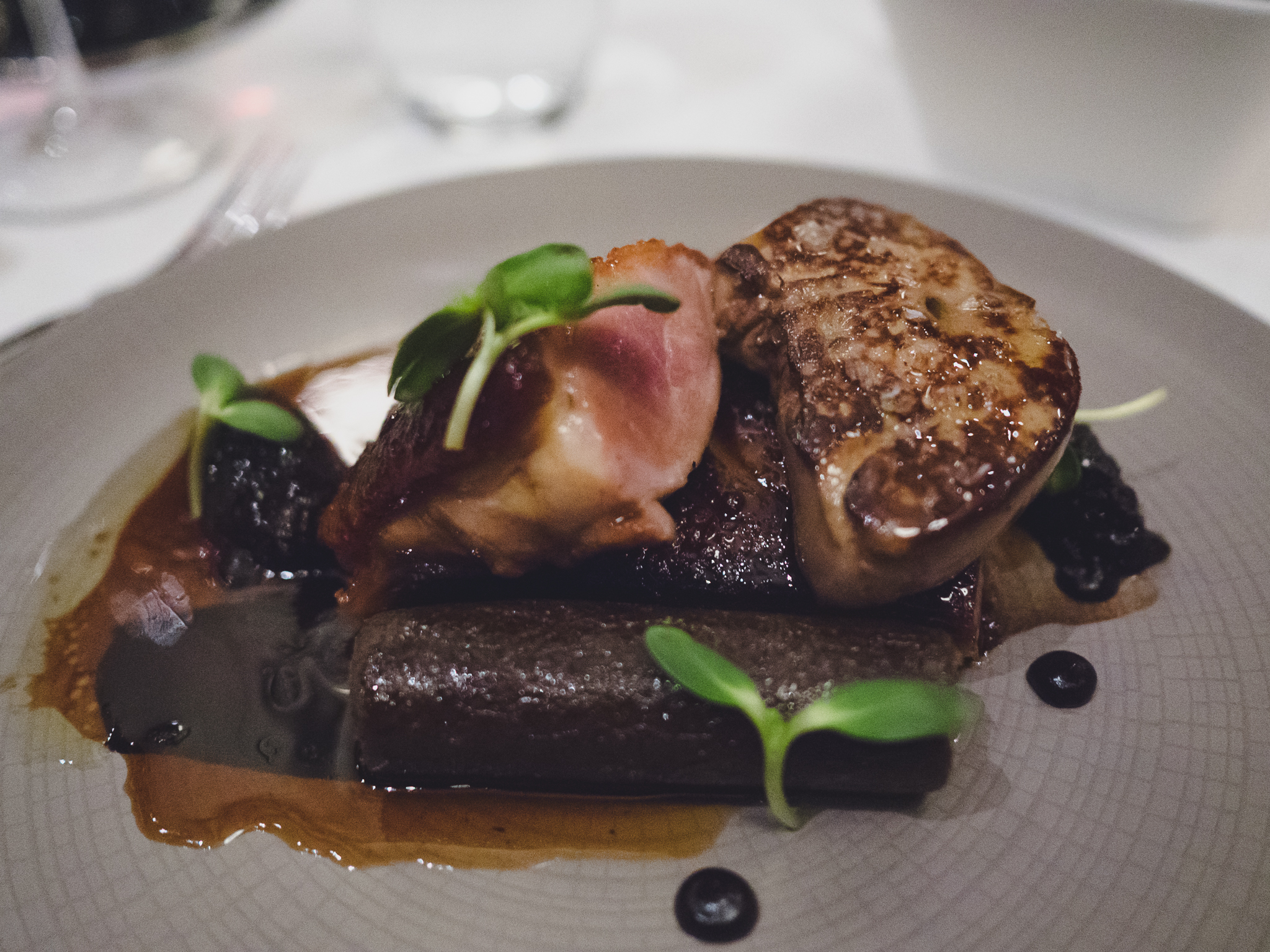 crispy duck breast with buckwheat confit tamale, sakura jus, cherry chili compote and seared foie gras enhancement.