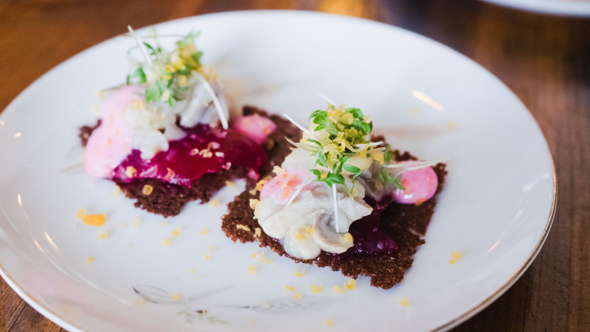 course 3, seafood menu. pickled herring, rye bread, beets and cured egg yolk.