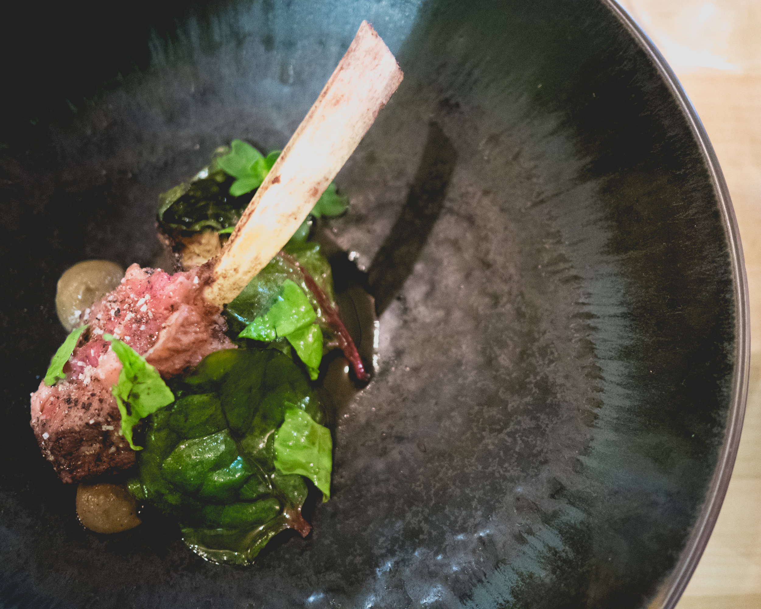 vi. windy hill goat chop and meatball, eggplant, malabar spinach, bone jus, coffee oil.