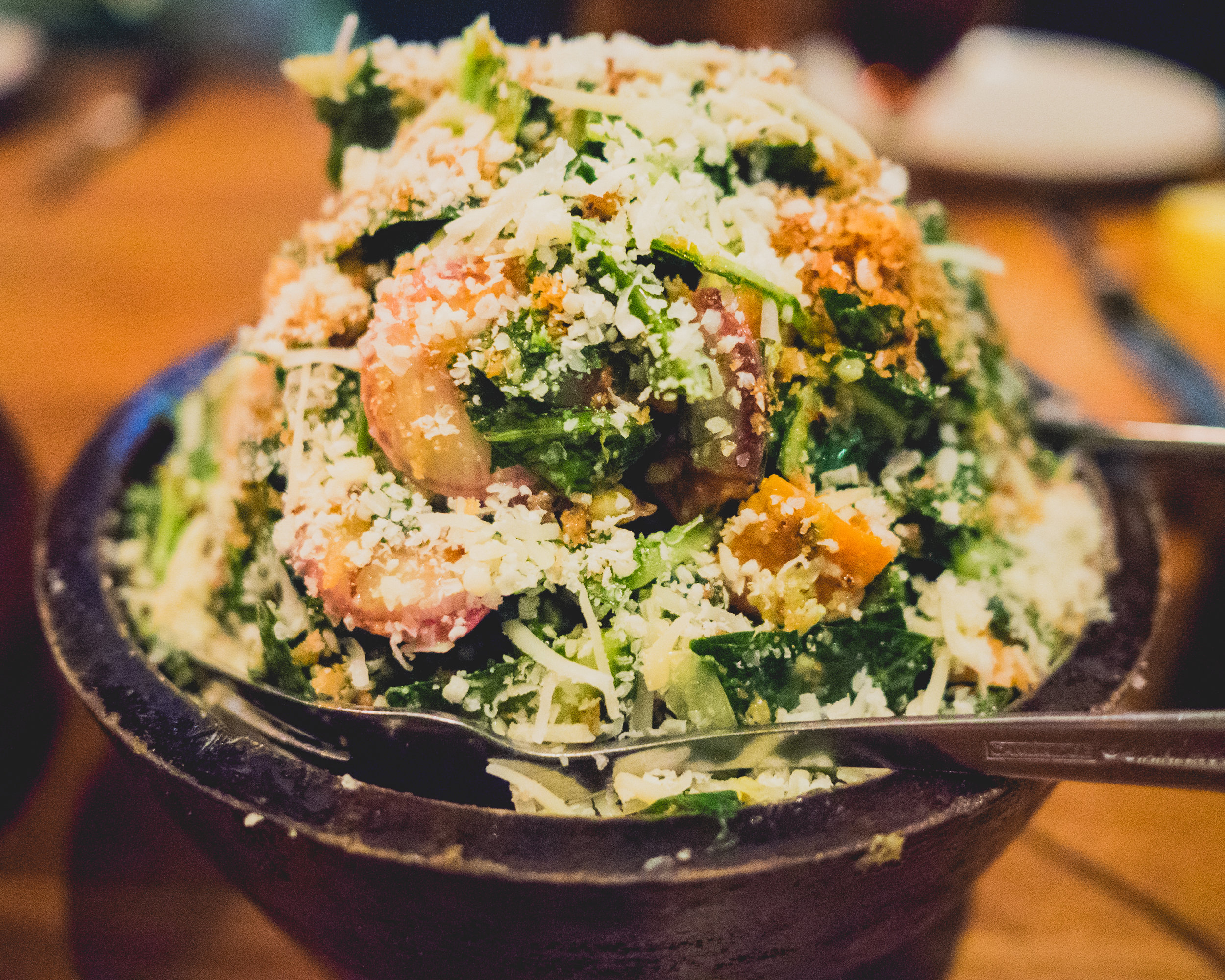 collard greens , sweet potato, lemon caper raisin vinaigrette, shaved onion, aged cheddar, bread crumbs.