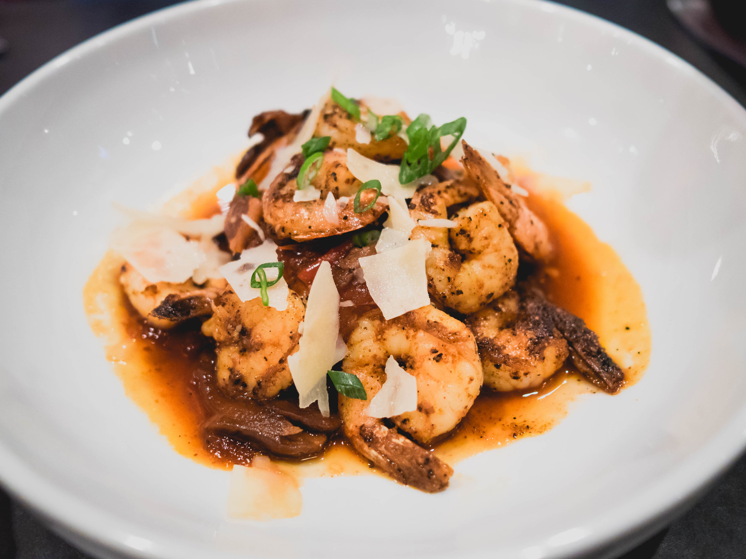 shimp & grits : cajun seared gulf shrimp, mushrooms, onions, peppers, smoky lager sauce, cheese grits.