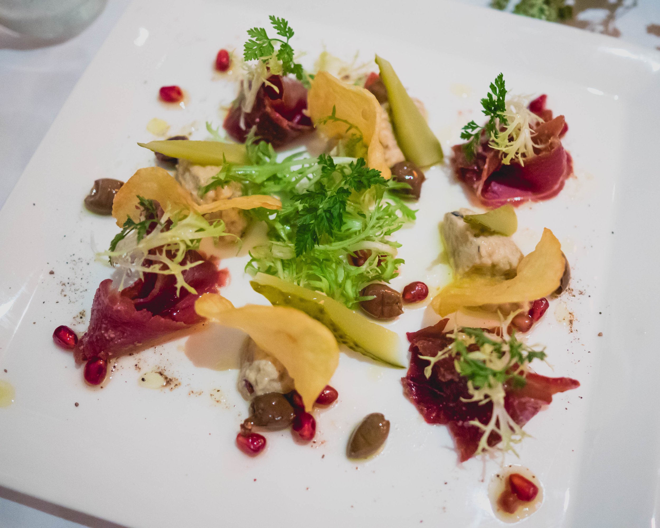 lebanese basturma at senses: thin sliced dried lebanese beef, babaganoush, pomegranate, herbs.