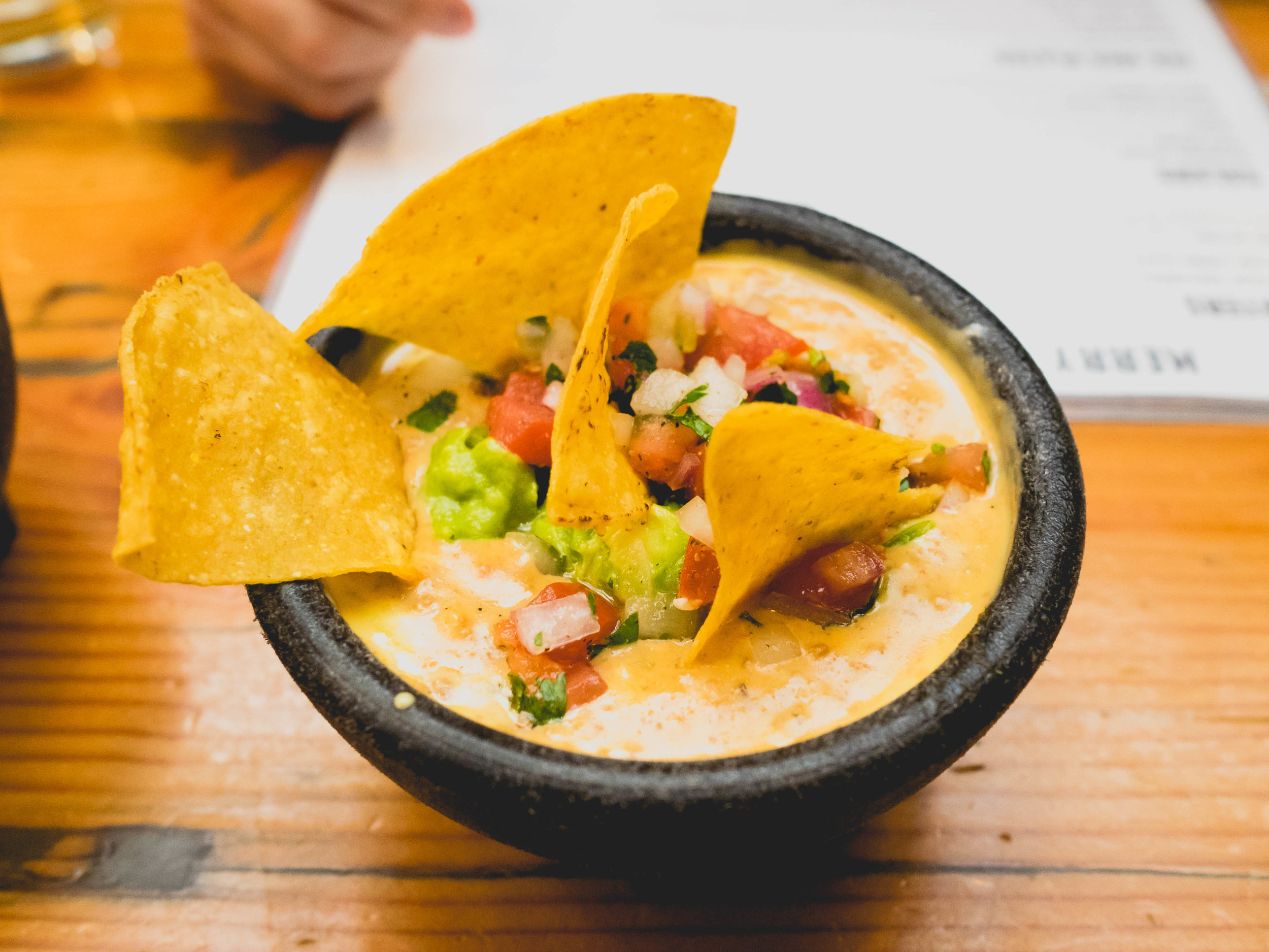 twisted cowgirl dip : queso mixed with ground beef and topped with guacamole & pico de gallo.