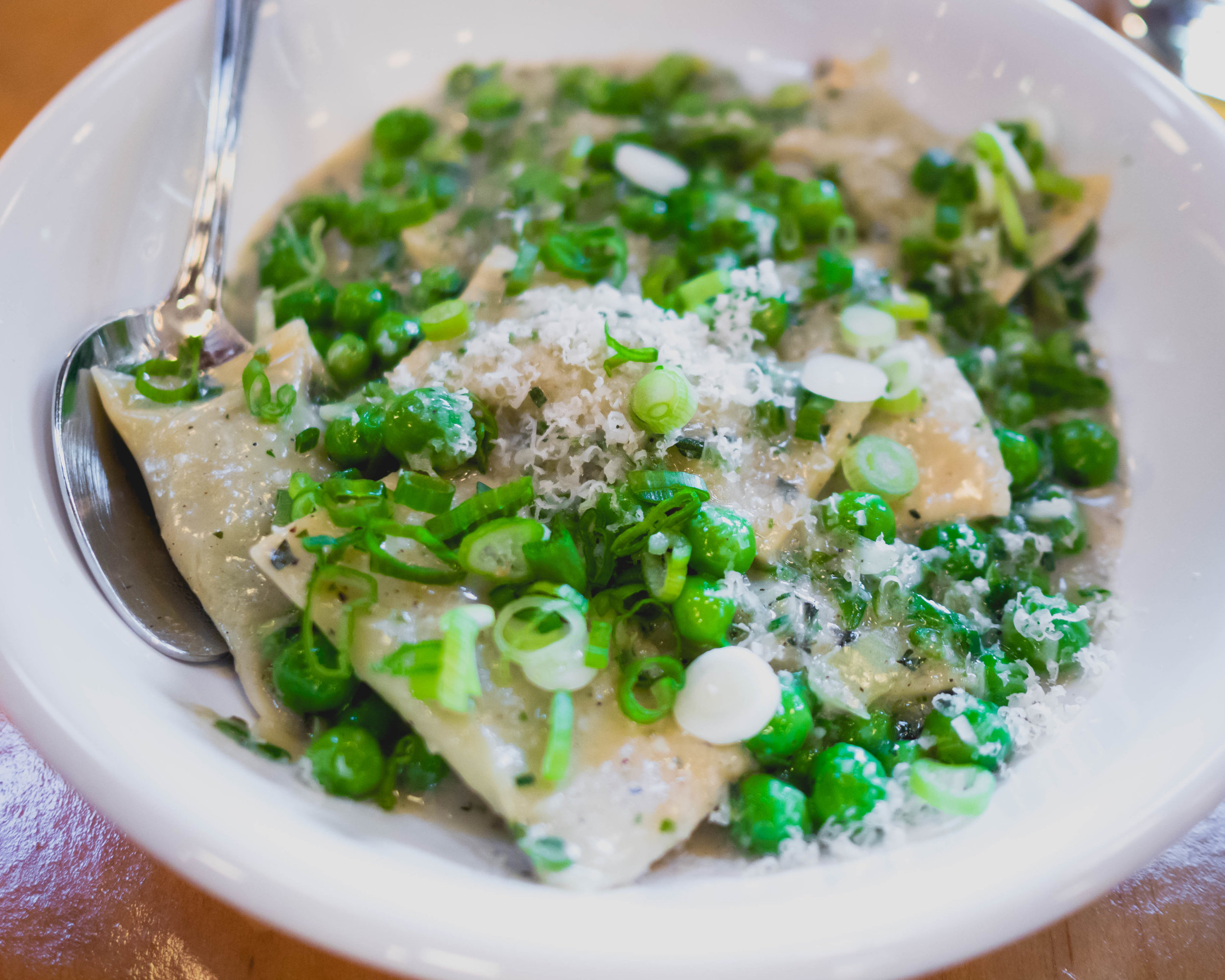 spring pea agnolotti with green garlic, parmesan, scallions.
