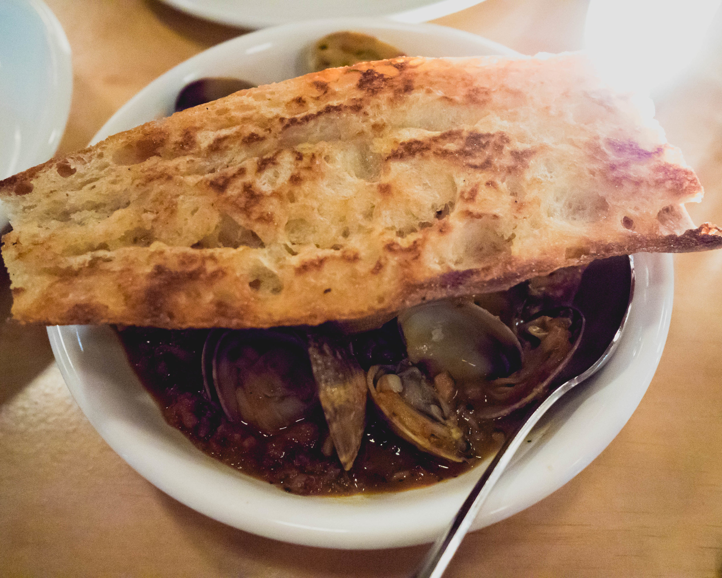 clams , merguez sausage, white beans, cavolo nero, sofrito, baguette.
