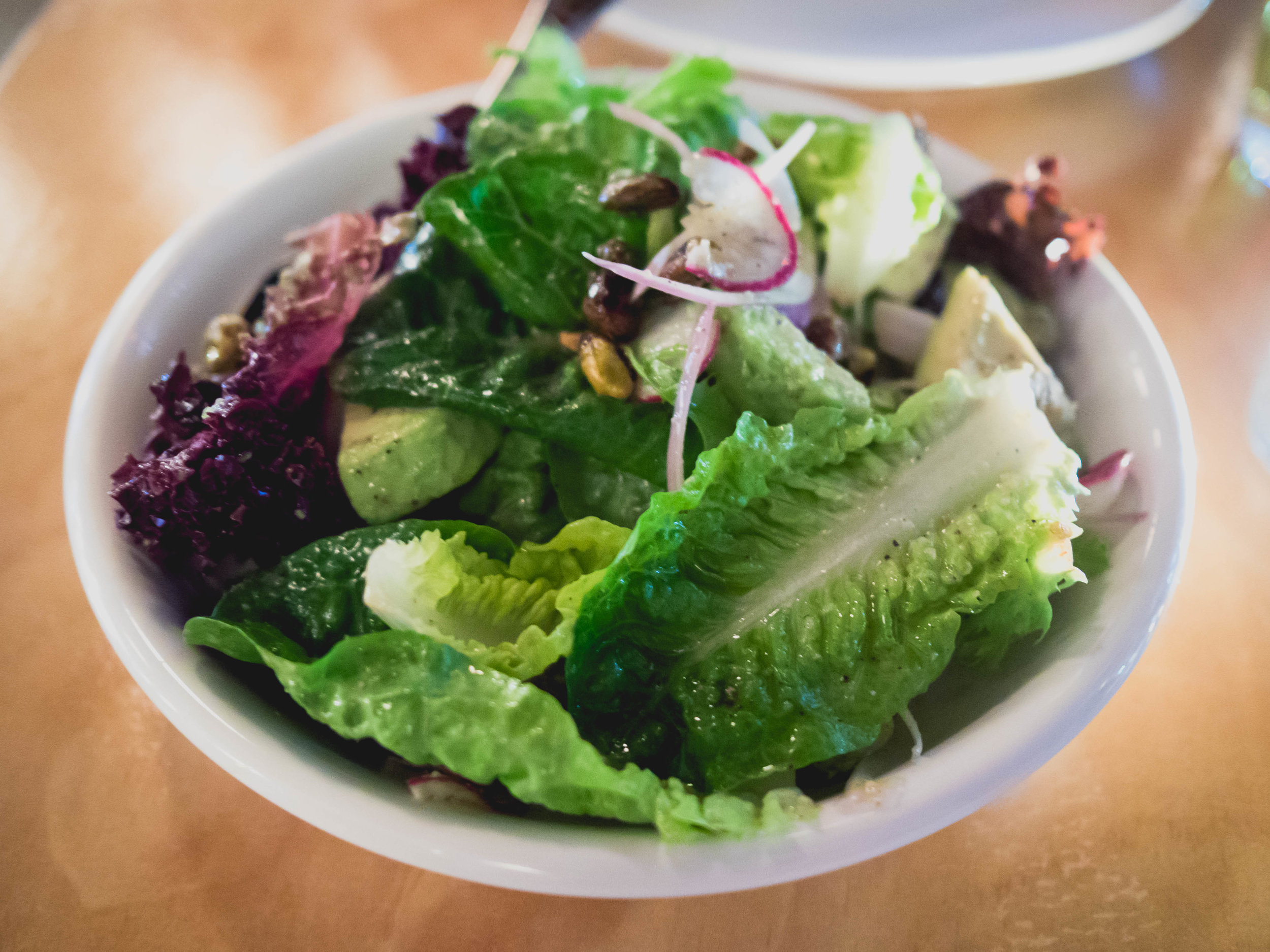 market lettuces , avocado, shallot, radish, pistachio, lemon.