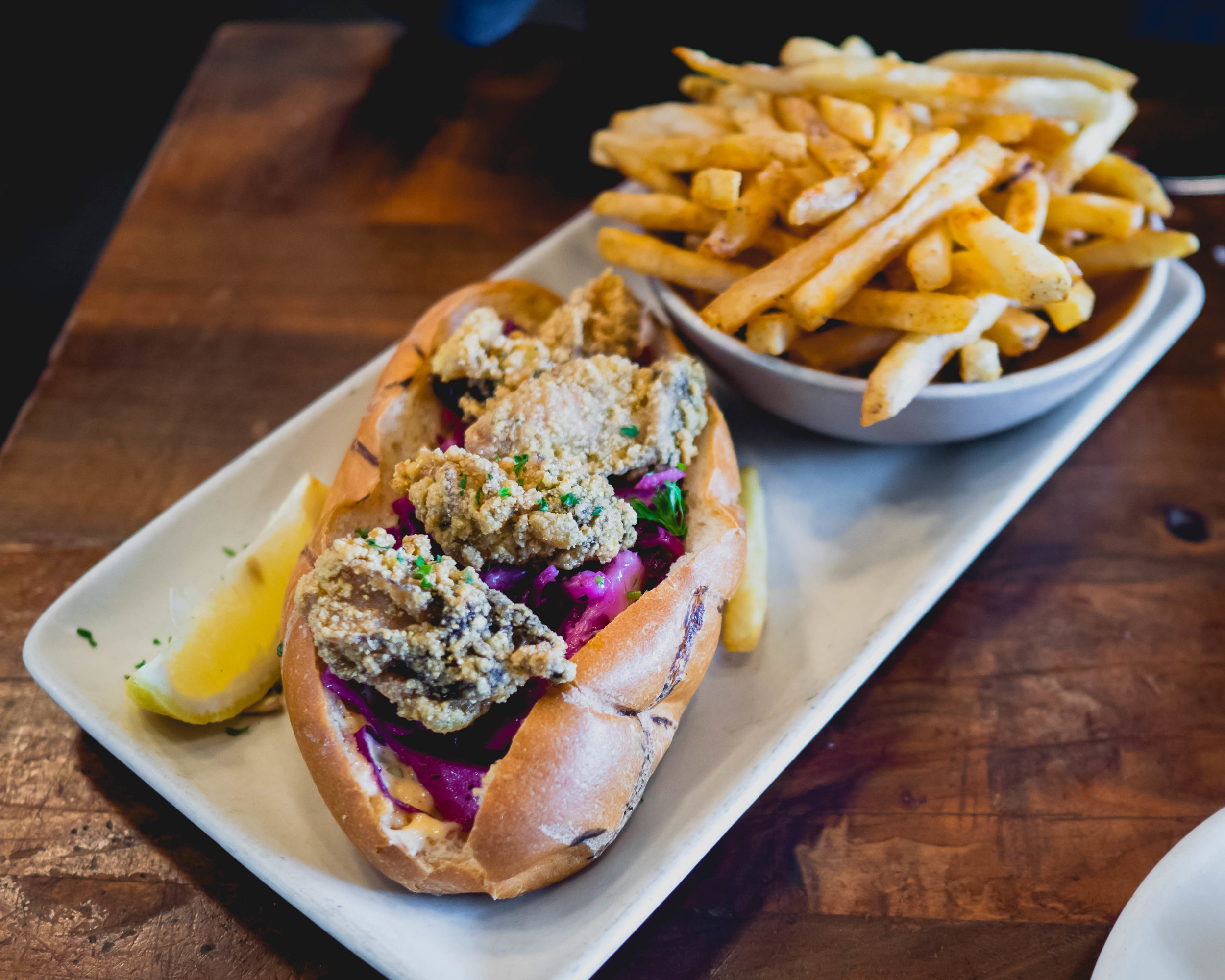 oyster po' boy sandwich : cornmeal fried oysters, hogwash slaw, remoulade, old bay fries.