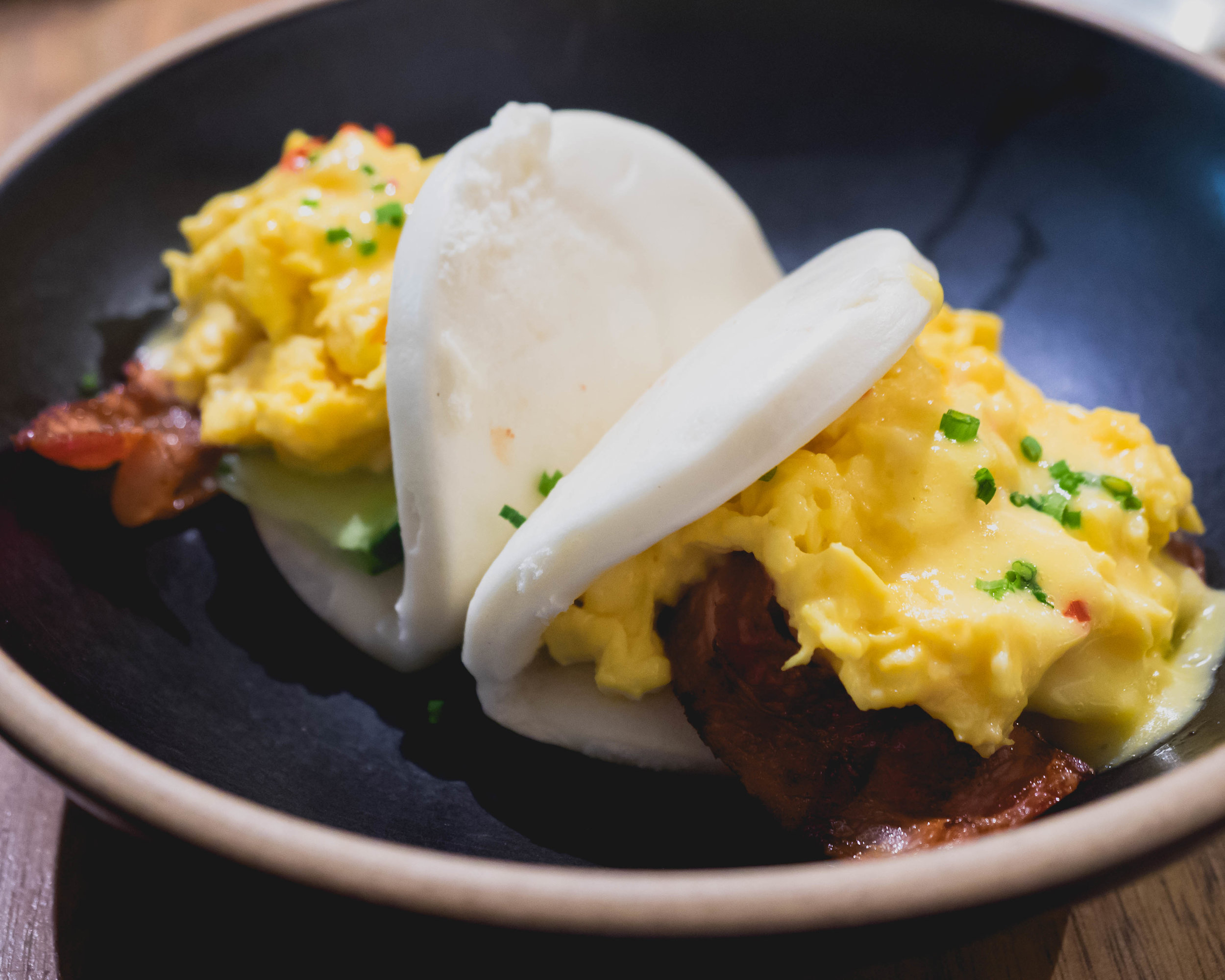 brekkie bao : chilli chives scrambled egg, bacon, cucumber, tomato relish, miso hollandaise.