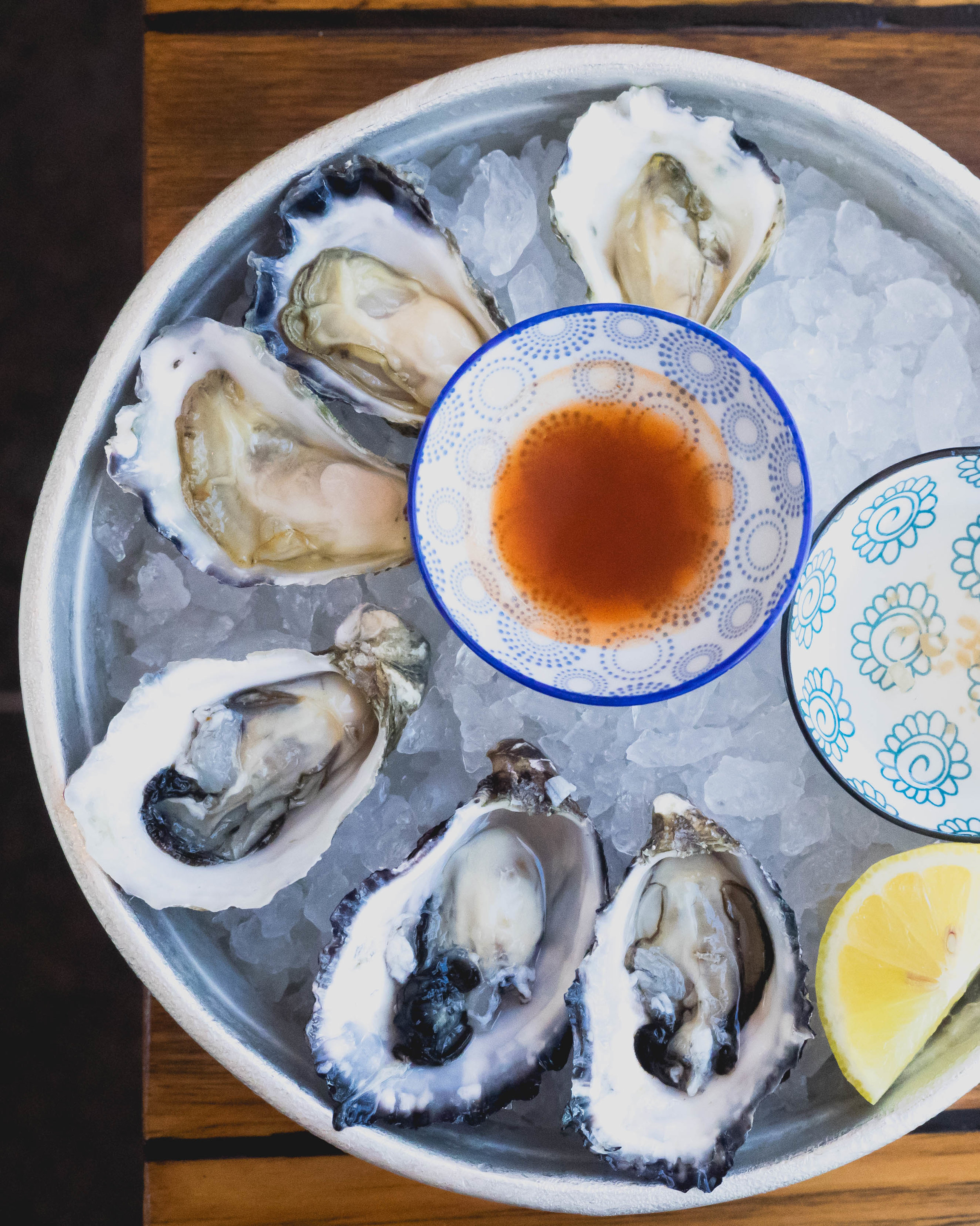 pacific and sydney rock oysters with hot sauce, lemon, mignonette .