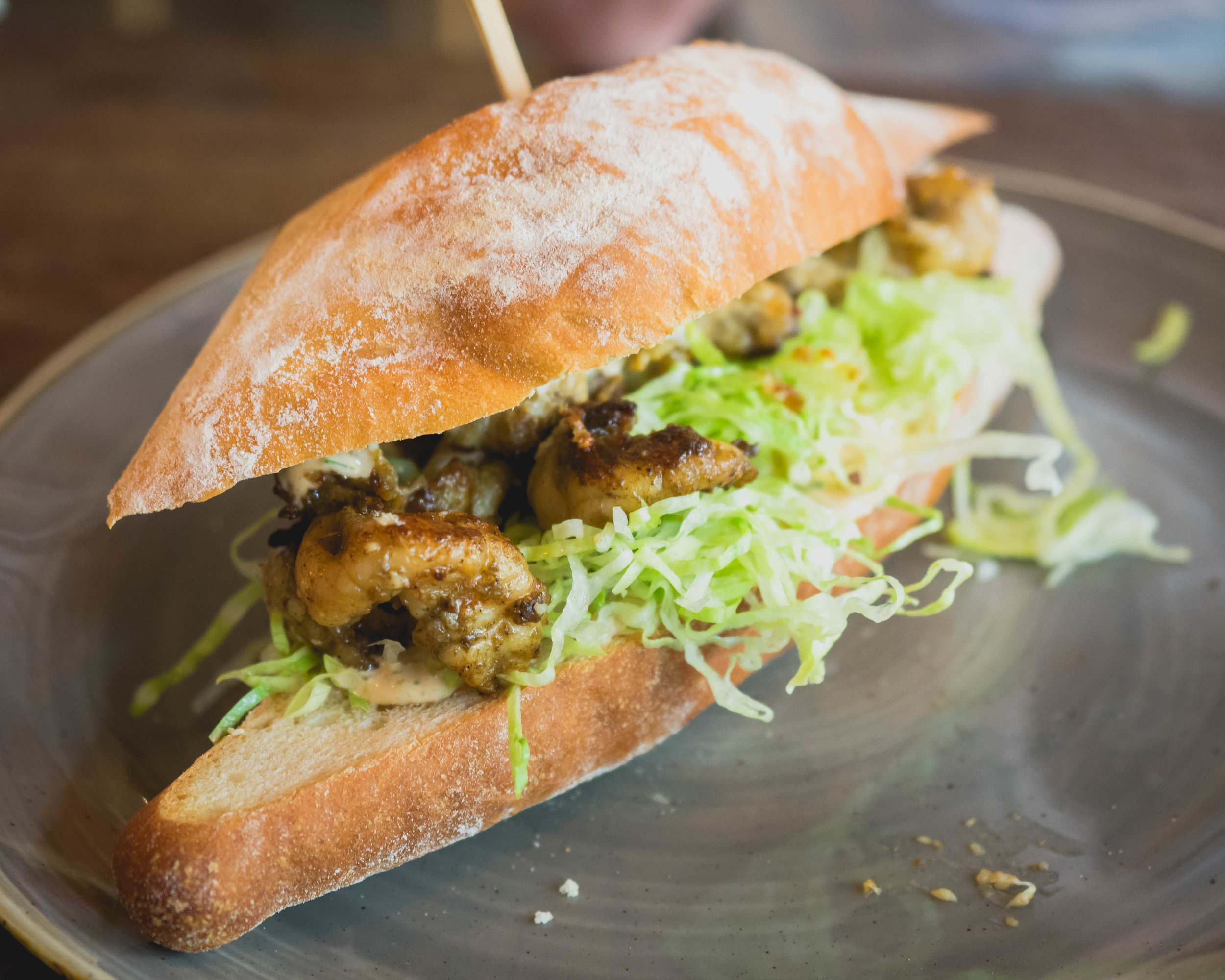 prawn po boy : pan fried creole spiced prawns, shredded iceberg, remoulade drizzle on crusty sourdough.