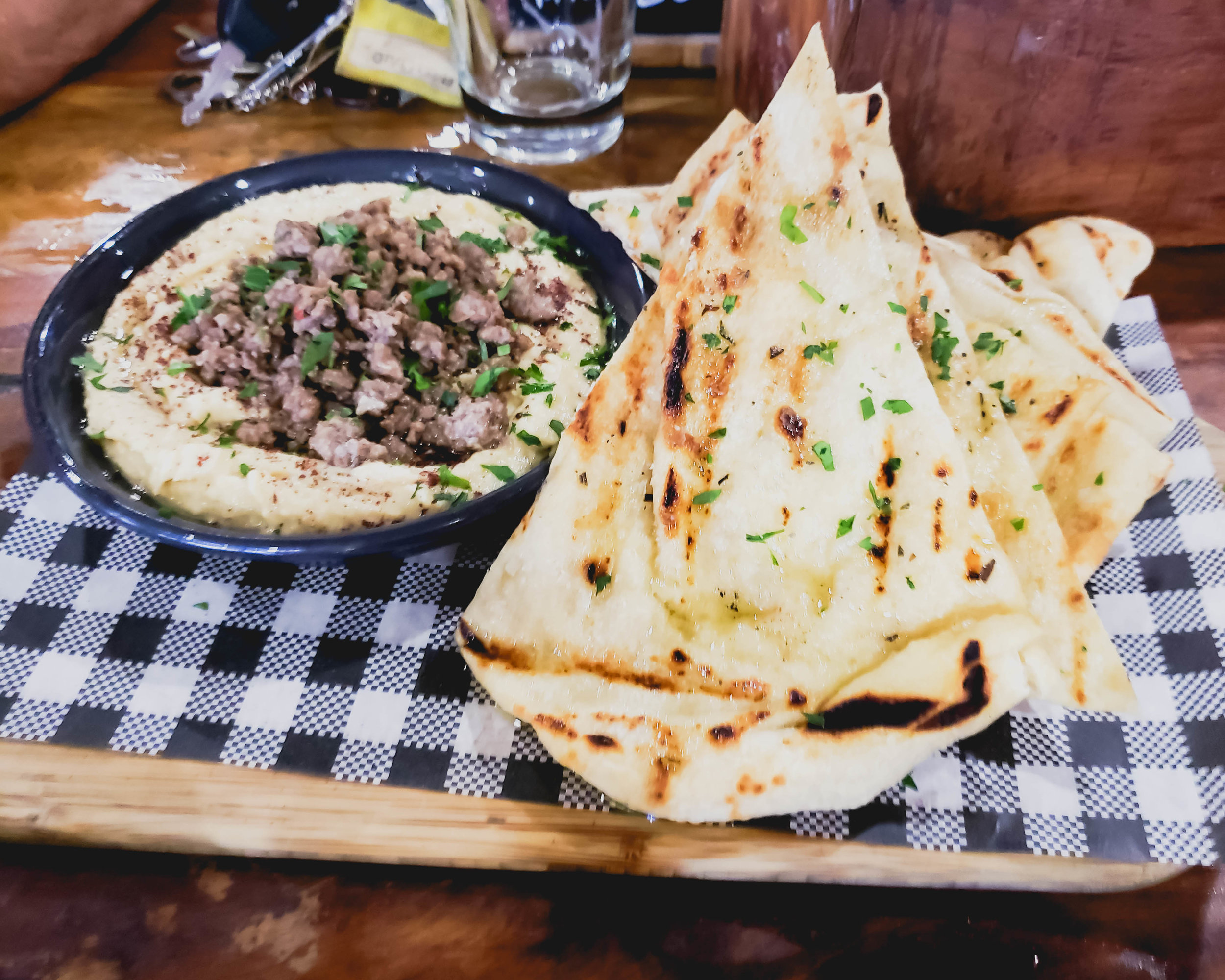 hummus with sumac, spiced lamb, grilled flatbread.