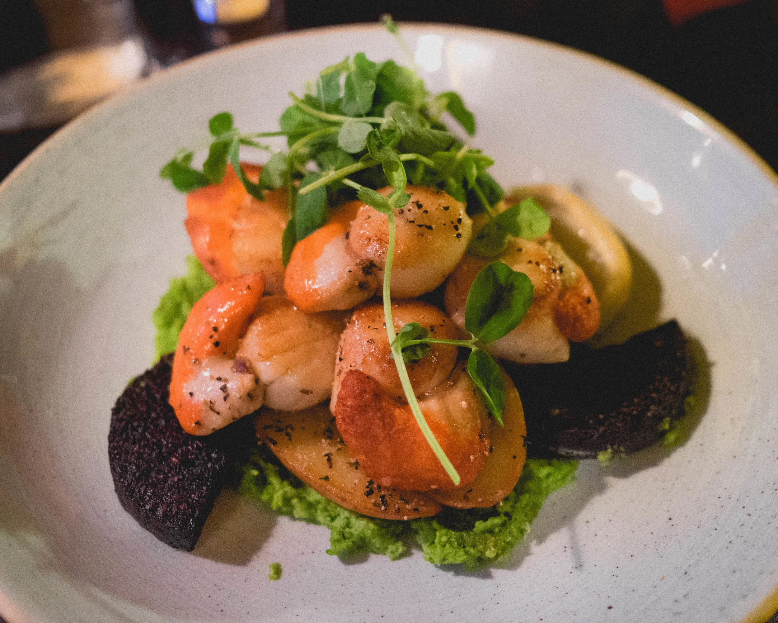 island pan fried scallops served atop stornoway black pudding, garden pea puree, bacon crumble and sauteed potatoes.
