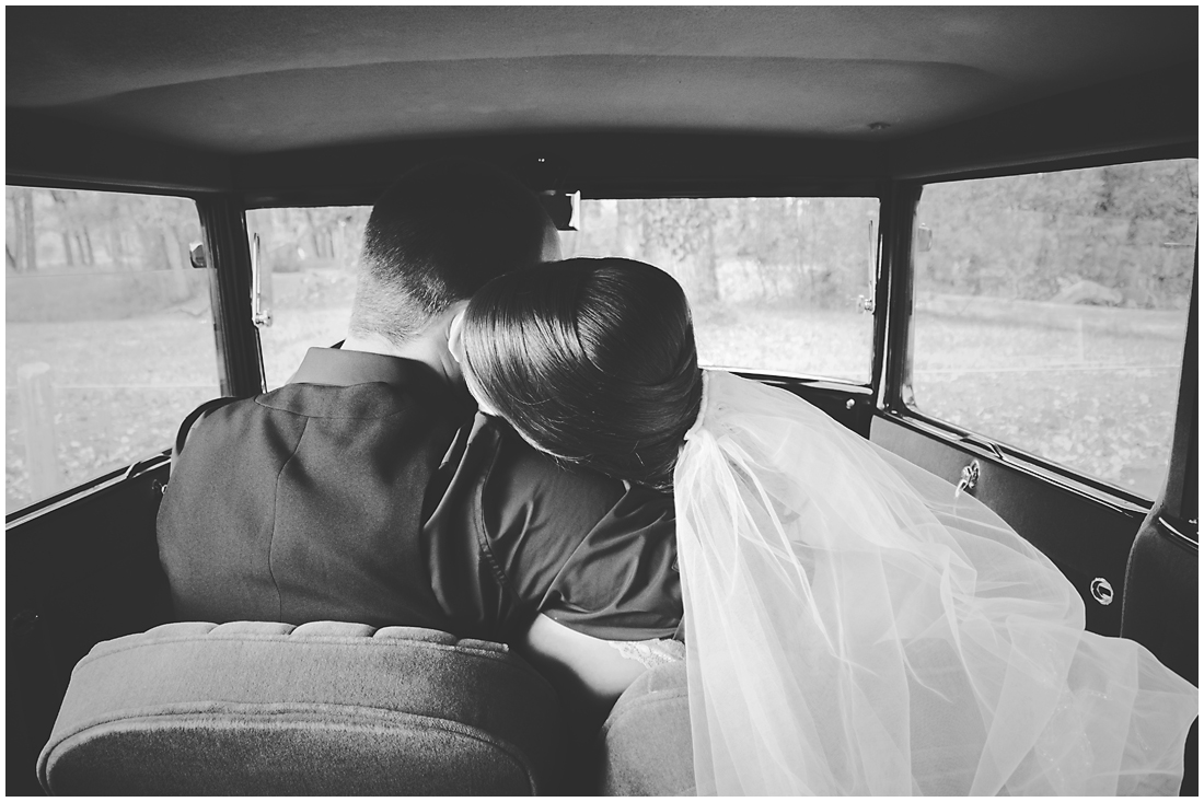 bride and groom in vintage car a model T enjoying a quiet snuggle in the middle of the day A stunning Fall wedding in Lethbridge Alberta - a religious church ceremony at the URC Church with stained glass windows, a quick stop at the Wooden Shoe for lunch and bridal party pictures at Indian battle park. #albertawedding #lethbridge #redwinewedding #redcolourscheme #babiesbreathboquet #indianbattlepark #woodshoe #overcastwedding #fallwedding #kissingcouple #brideandgroom #emotionalwedding #church #churchceremony