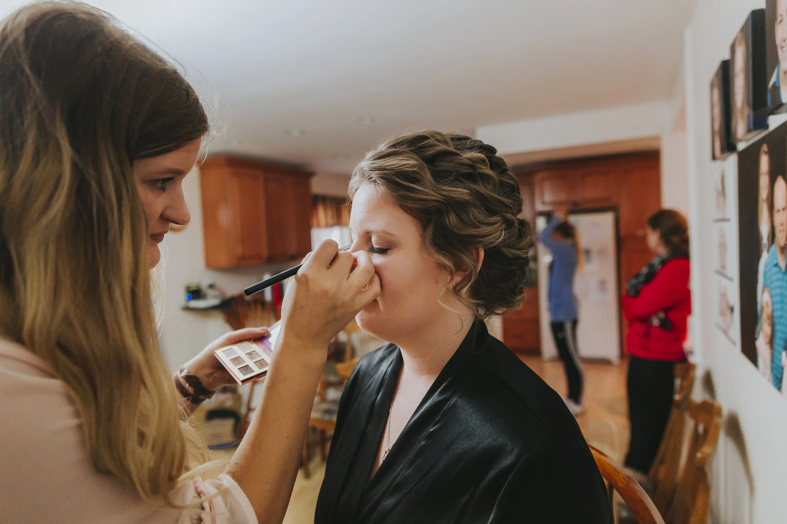 Bridal Prep, with the makeup artist. A rainy forest wedding in Lynden Washington, featuring teal blue accents, rustic details, umbrellas and a large bridal party. #rain #wedding #lynden #washington #umbrella #spring #teal #grey #brown #trees #romantic #documentarywedding #unposed #romanticposes #couple #largebridalparty Photography by Christina Voorhorst of Mimsical Photography. Do not alter, crop, edit or share these images without proper credit or permission. www.mimsicalphotography.com 