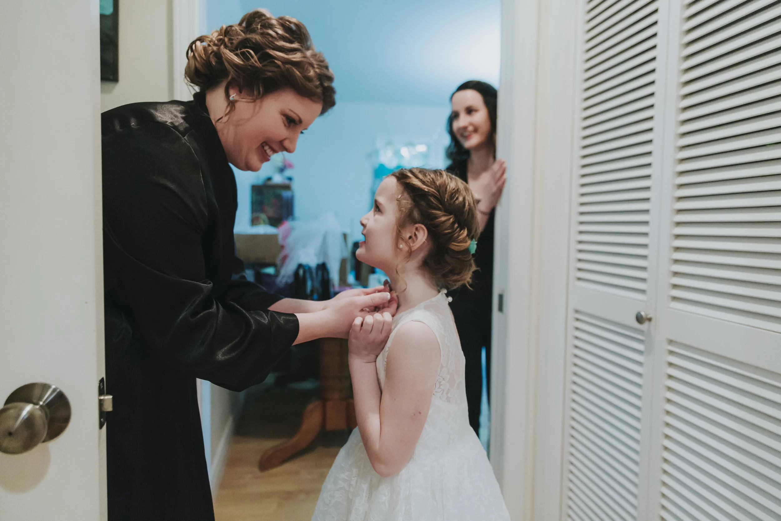 Flowergirl and bride sharing a sweet moment while getting ready. A rainy forest wedding in Lynden Washington, featuring teal blue accents, rustic details, umbrellas and a large bridal party.#rain #wedding #lynden #washington #umbrella #spring #teal #grey #brown #trees #romantic #documentarywedding #unposed #romanticposes #couple #largebridalparty Photography by Christina Voorhorst of Mimsical Photography. Do not alter, crop, edit or share these images without proper credit or permission. www.mimsicalphotography.com 