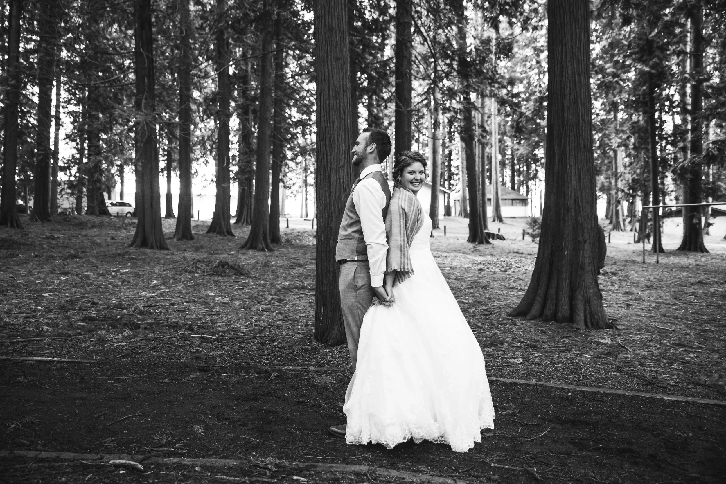 First look before they see each other, back to back photograph A rainy forest wedding in Lynden Washington, featuring teal blue accents, rustic details, umbrellas and a large bridal party.#rain #wedding #lynden #washington #umbrella #spring #teal #grey #brown #trees #romantic #documentarywedding #unposed #romanticposes #couple #largebridalparty Photography by Christina Voorhorst of Mimsical Photography. Do not alter, crop, edit or share these images without proper credit or permission. www.mimsicalphotography.com 