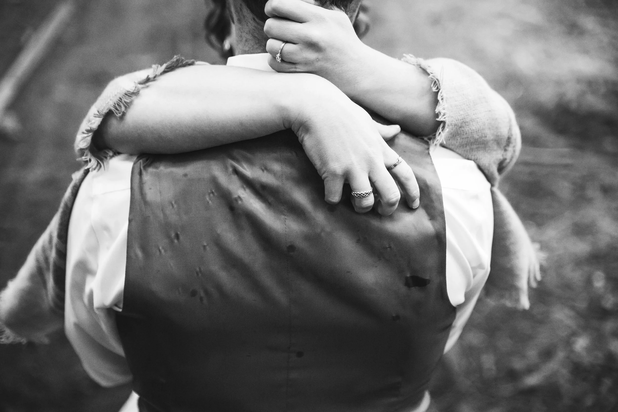Close up of hands and rain drop spattered vest during first look A rainy forest wedding in Lynden Washington, featuring teal blue accents, rustic details, umbrellas and a large bridal party.#rain #wedding #lynden #washington #umbrella #spring #teal #grey #brown #trees #romantic #documentarywedding #unposed #romanticposes #couple #largebridalparty Photography by Christina Voorhorst of Mimsical Photography. Do not alter, crop, edit or share these images without proper credit or permission. www.mimsicalphotography.com 