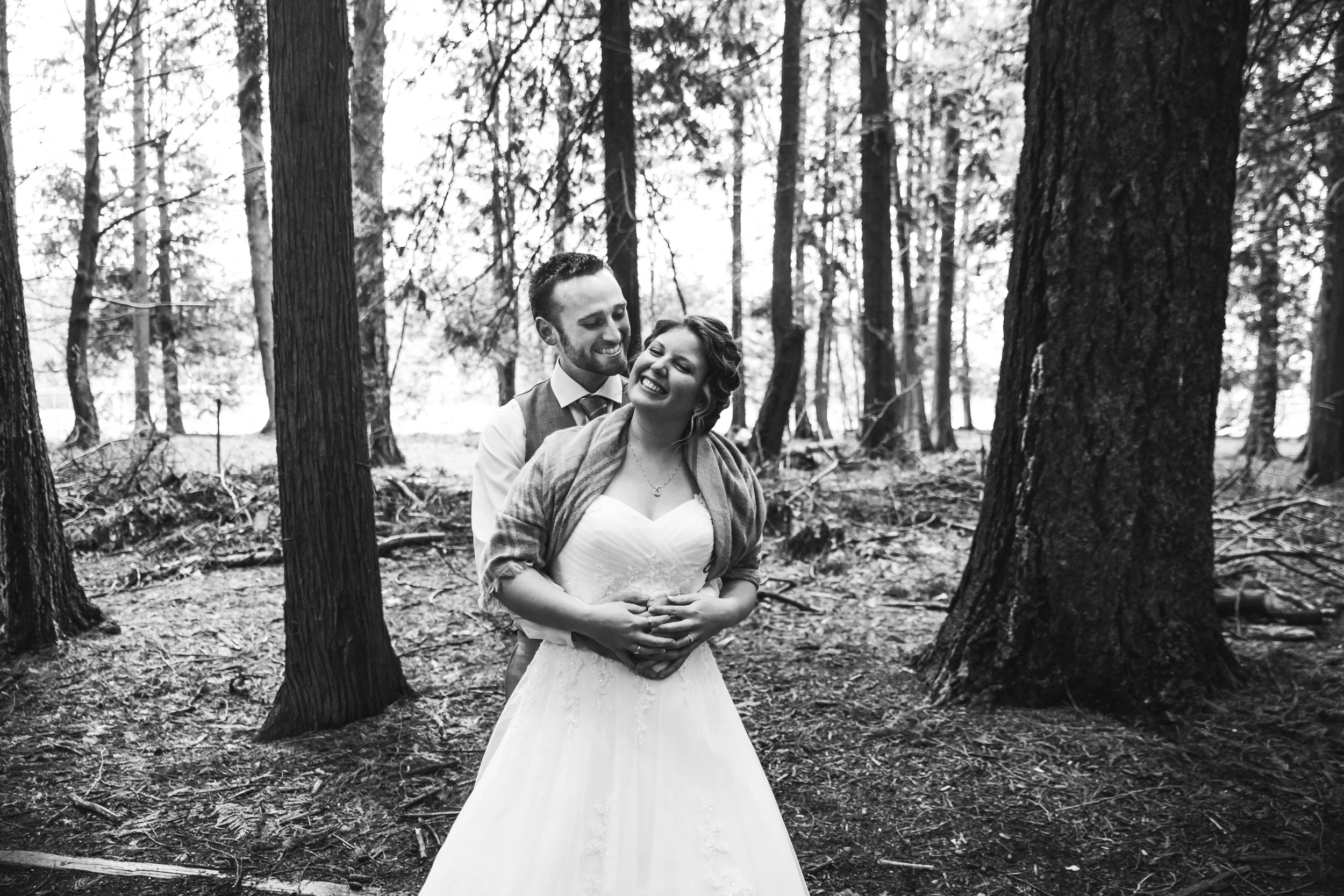 A rainy forest wedding in Lynden Washington, featuring teal blue accents, rustic details, umbrellas and a large bridal party.#rain #wedding #lynden #washington #umbrella #spring #teal #grey #brown #trees #romantic #documentarywedding #unposed #romanticposes #couple #largebridalparty Photography by Christina Voorhorst of Mimsical Photography. Do not alter, crop, edit or share these images without proper credit or permission. www.mimsicalphotography.com 