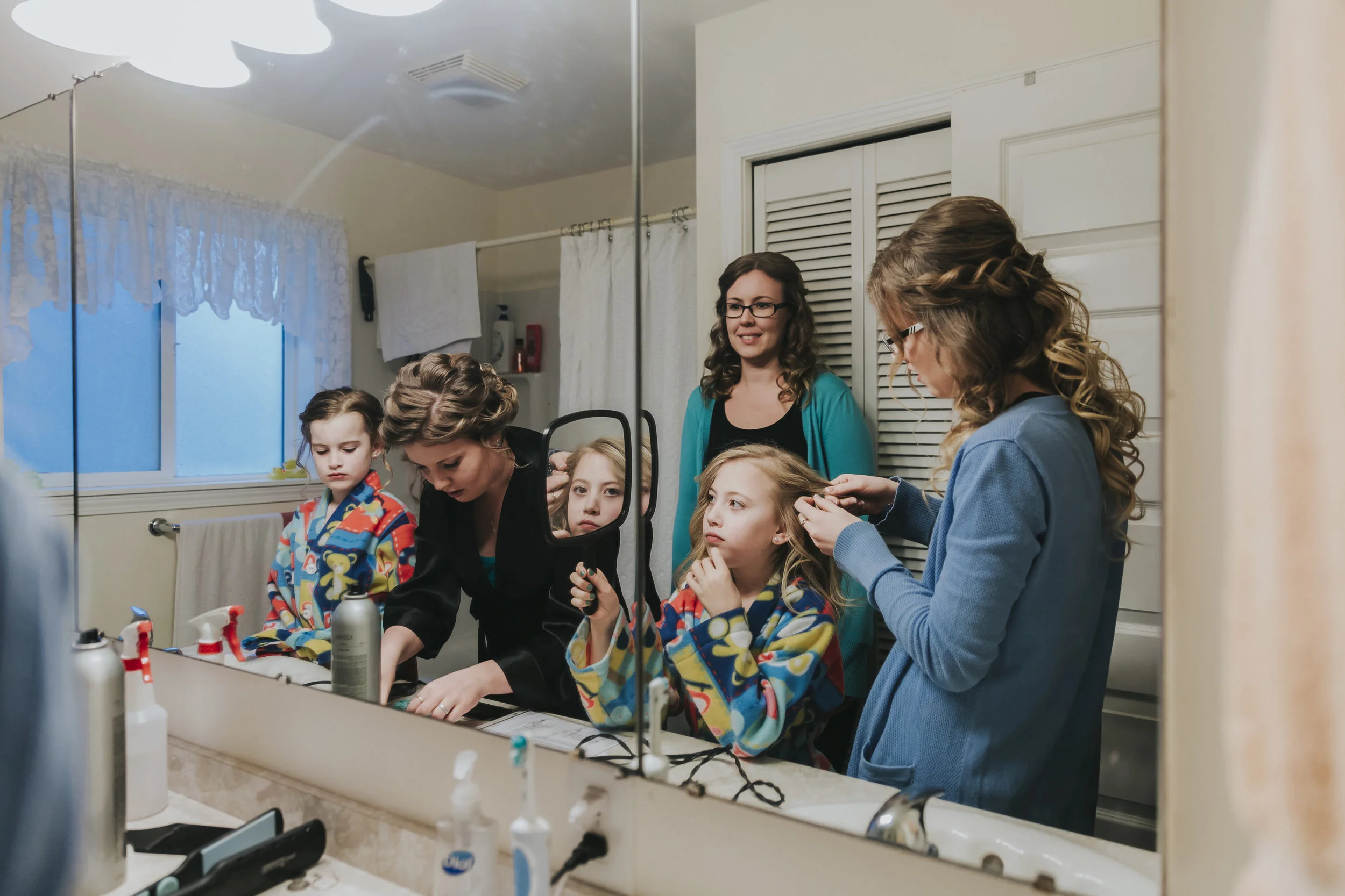Bride and flower girls getting ready in their family bathroom. A rainy forest wedding in Lynden Washington, featuring teal blue accents, rustic details, umbrellas and a large bridal party. #rain #wedding #lynden #washington #umbrella #spring #teal #grey #brown #trees #romantic #documentarywedding #unposed #romanticposes #couple #largebridalparty Photography by Christina Voorhorst of Mimsical Photography. Do not alter, crop, edit or share these images without proper credit or permission. www.mimsicalphotography.com 