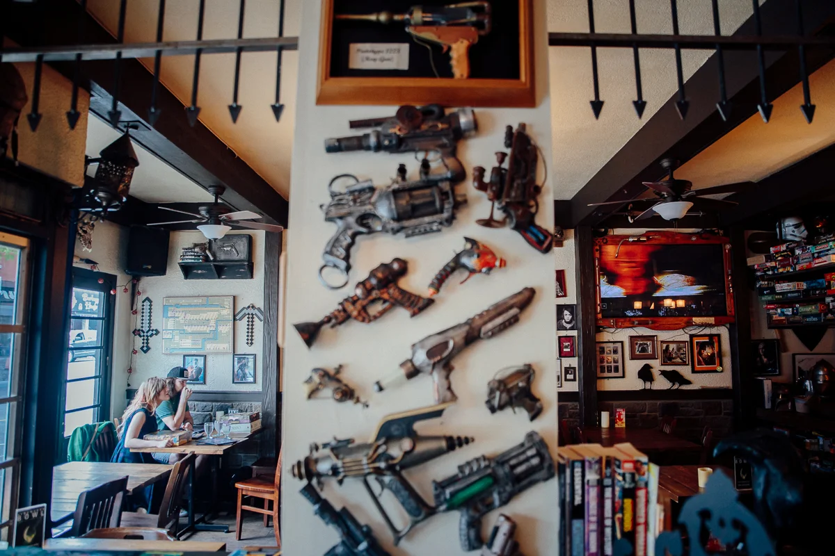 Couple sitting in Storm Crow Tavern playing board games. Storm Crow Tavern Documentary Engagement Photography, Nerd Bar, Board Games by Mimsical Photography. Real stories about Real Couples that are just as unique as they are.