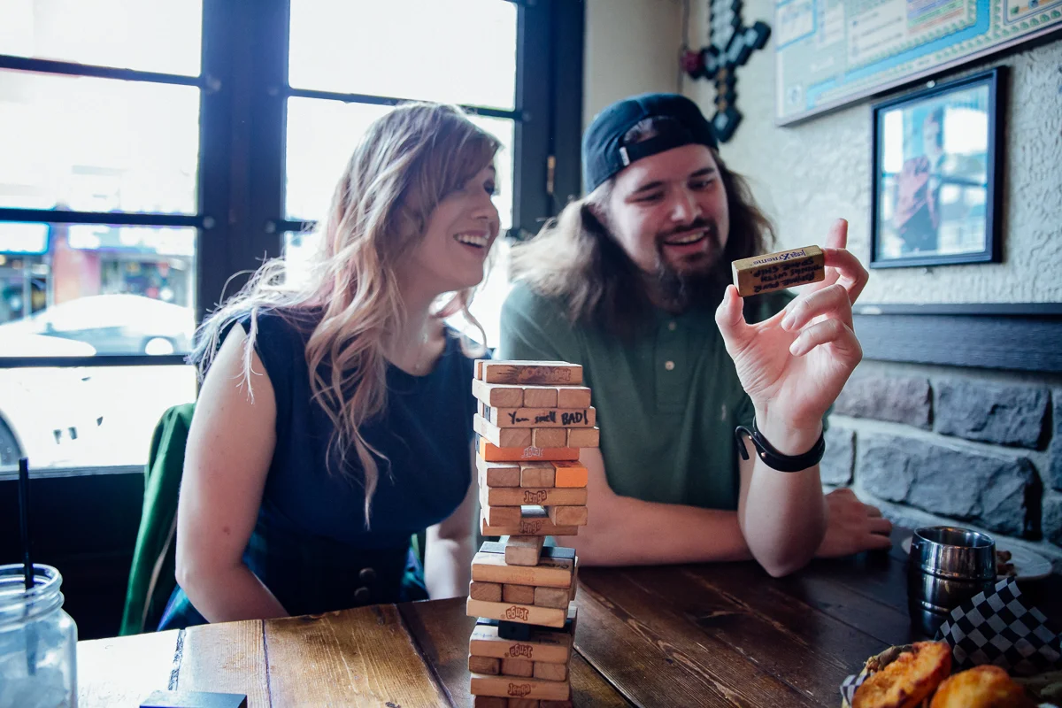 Alternate Jenga - write challenges or dares on the blocks and break the ice with friends. Storm Crow Tavern Documentary Engagement Photography, Nerd Bar, Board Games by Mimsical Photography. Real stories about Real Couples that are just as unique as they are. #unique #vibrant #personality #nerd #princess #ecclectic #gamer #couple #tavern #vancouver #candid #storytelling