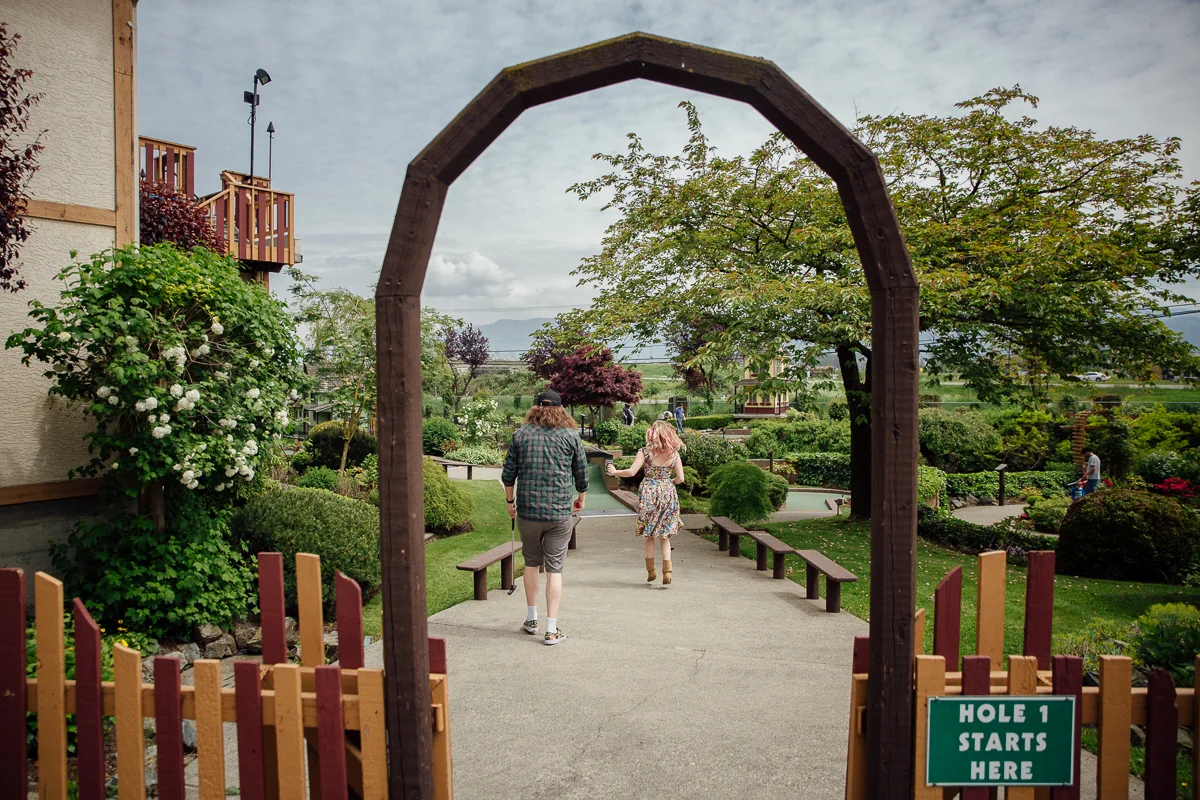 Hole one at Castle Fun park, skipping Castle Fun Park Documentary Engagement Photography, minigolf date by Mimsical Photography. Real stories about Real Couples that are just as unique as they are. #unique #vibrant #personality #nerd #princess #ecclectic #gamer #couple #minigolf #vancouver #candid #storytelling #connect #datesforcouples #arcade #arcadedate