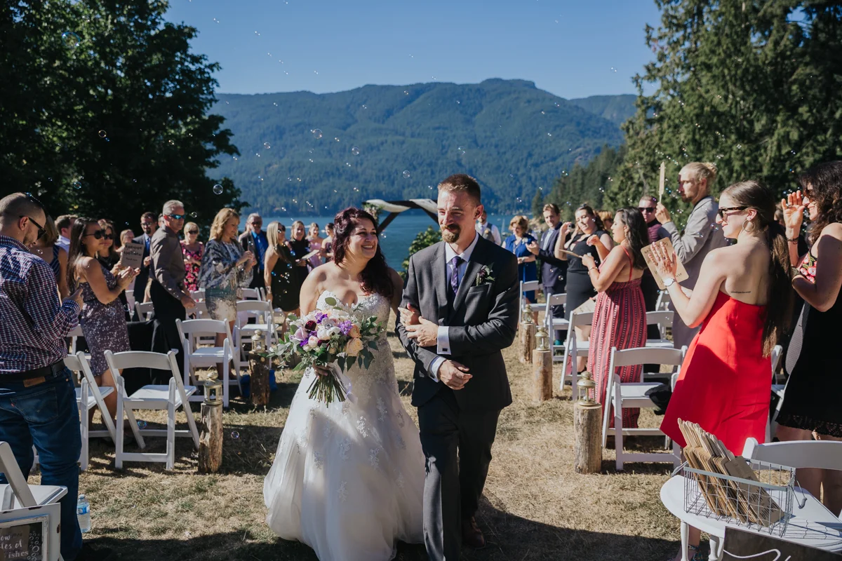 bubble exit or processional from outdoor wedding Mimsical Photography Documentary Wedding Photography, Camp Howdy, Belcarra Provincial Park, North Vancouver. Purple and Grey Wedding Colours, Natural Greenery, Rustic Details, Summer, Lace and chiffon, big wedding, greek, lower mainland, british columbia, real, genuine, candid
