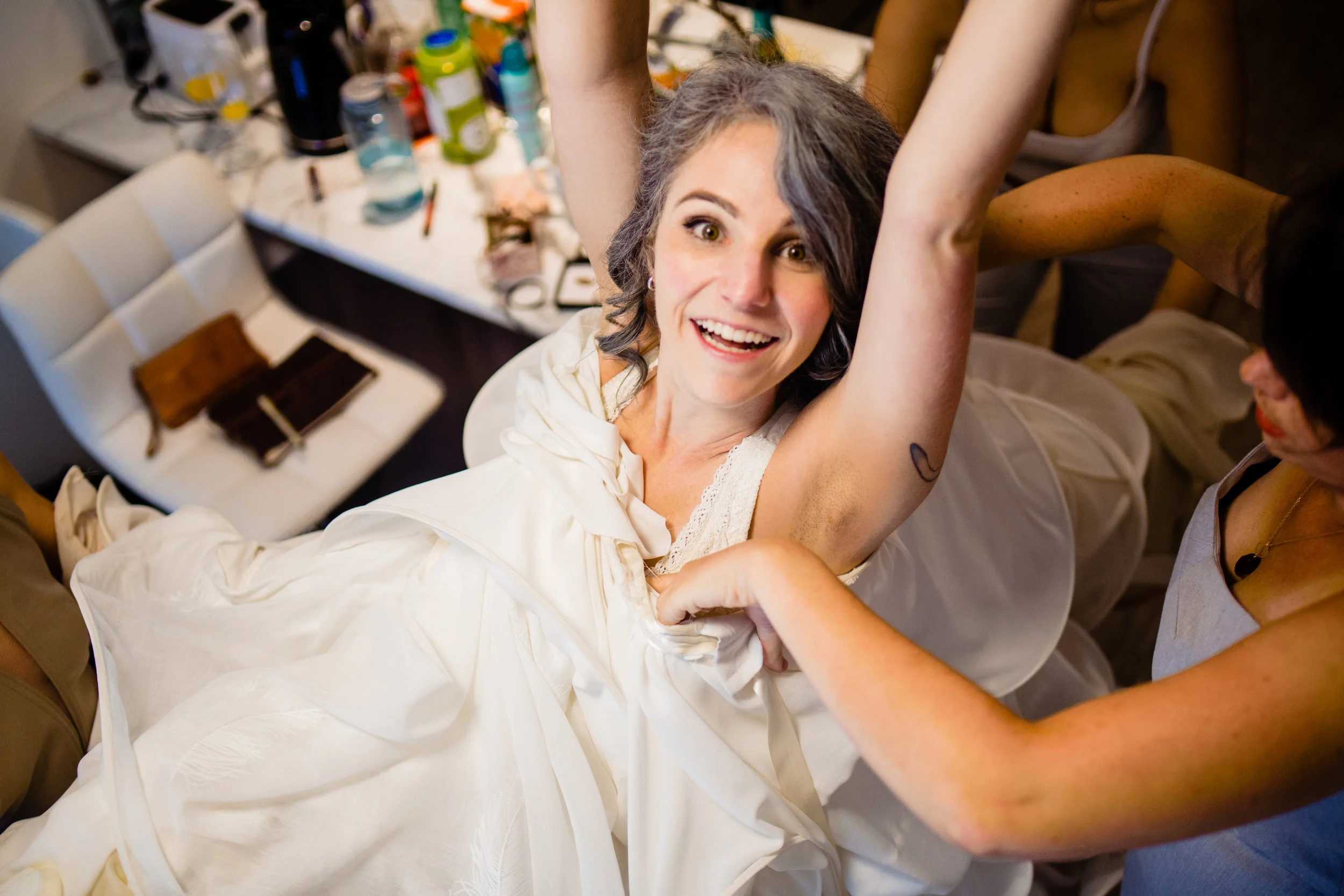 Bride getting in to her handmade dress during bridal prep Cuckoo Trattoria and Pizzeria Wedding Photographer Vancouver Island Coombs, BC Goats on the Roof Market. Eclectic Formal quirky DIY artistic wedding full of handmade details and laughter. #fun #candid #storytelling #storytellingphotographer #bride #groom #weddinginspo #realwedding #horns #handmade #DIYwedding #DIYinspo #handmaderings #nobouquet #outdoor #pizzeria 