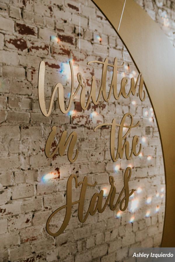 The couple had a custom golden crescent moon made for their backdrop, accented with a star sprinkled gobo on the exposed brick, and bistro lights overhead to simulate stars above.