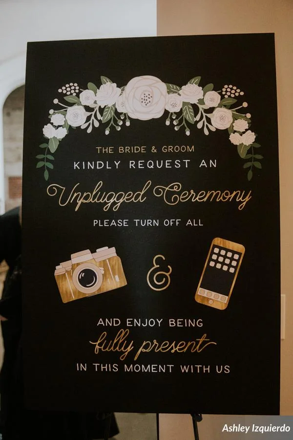 A black and gold sign accented with matching florals welcomed guests and let them know this was going to be an intimate, unplugged ceremony.