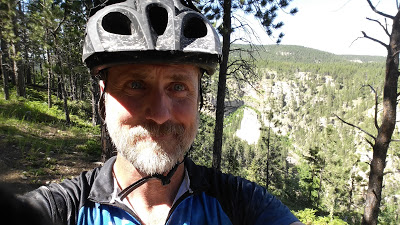 Selfie on a climb with a nice "canyon" on the right. Somewhere near mile 65?