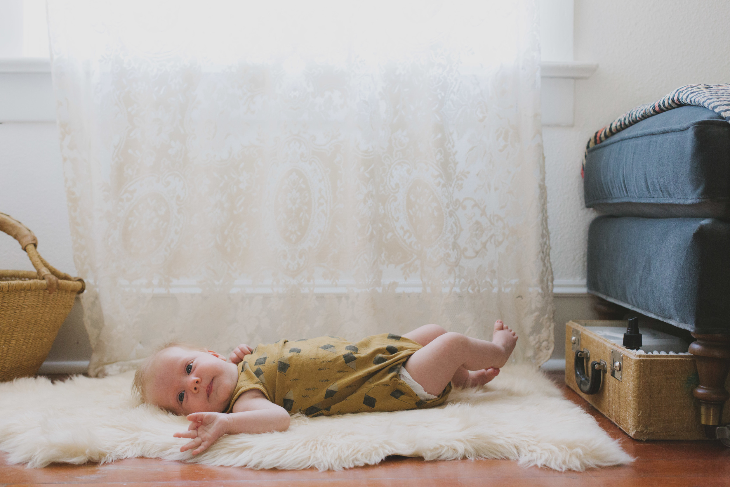 never a fan of proper changing tables, poppy has a sheepskin rug, with diaper supplies tucked away beneath the chaise in an old suitcase