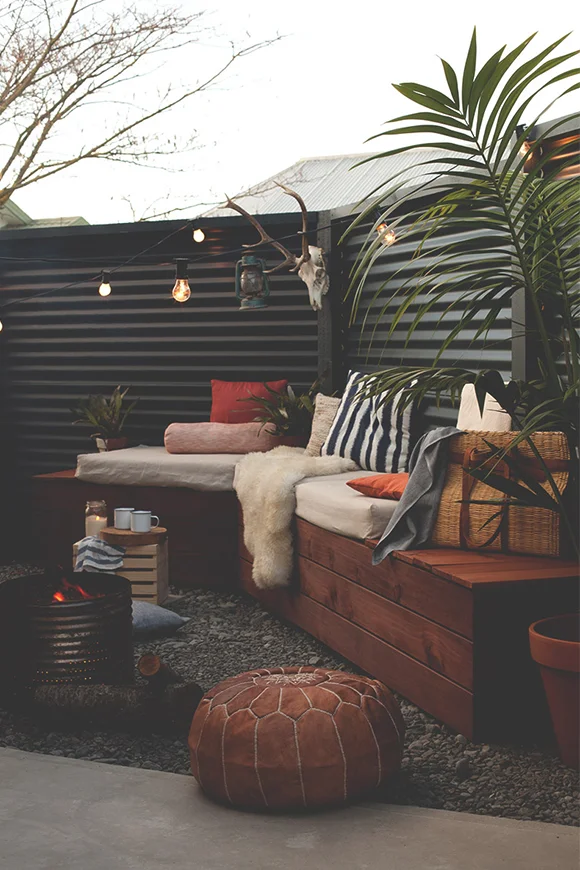 Use cushions, lighting and blankets to make an outdoor space more comfortable in winter. Image via  Blackbird .