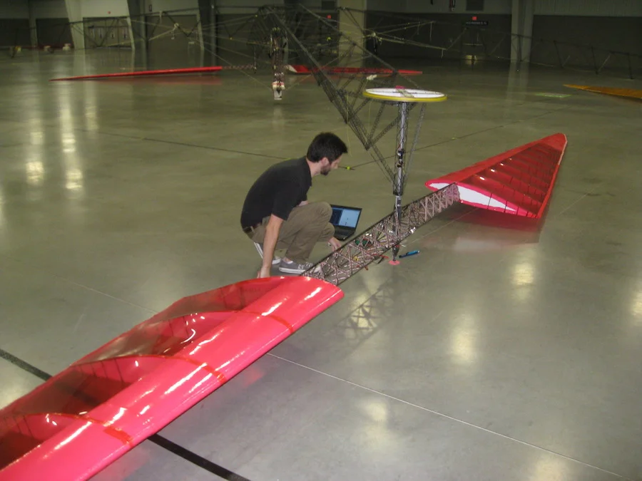 Team member Ben Berry calibrates a strain gauge mounted on the rotor shaft (the rotor”s truss spars are also visible)