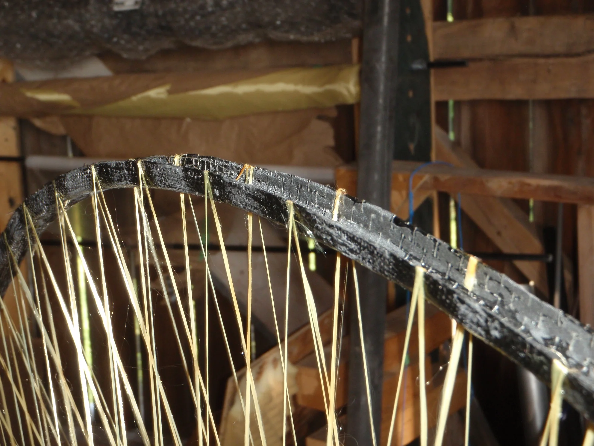 Shown is the rim of the completed spool. Note the crossover point of the original set of spokes. Also note the difference in the bond angle between the inner spokes and the outer spokes where they meet the rim.