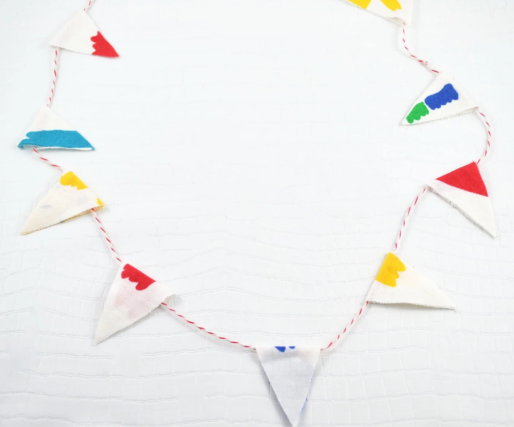 Homemade Bunting using material and gluing it closed with baker's twine. Photo Credit: Michelle Somers