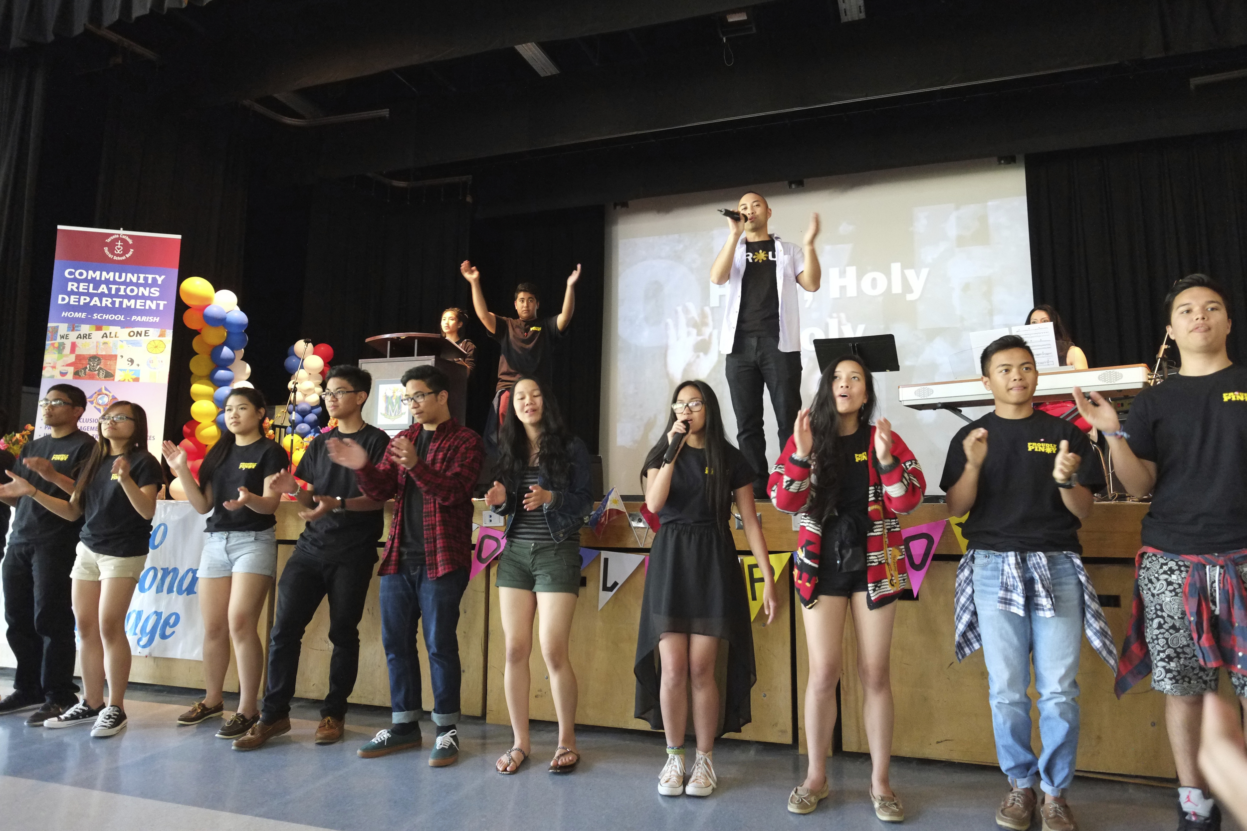 TCDSB Staff Michael Consul leads the students in celebration. Photo by JC Bonifacio.