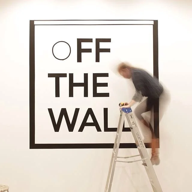 Composed of black tape on a wall and captured at a slow shutter speed to show the logo in stark relief with the blurred bodies present it in-situ. Designed in collaboration with Jessica Hong at the University of Alberta.