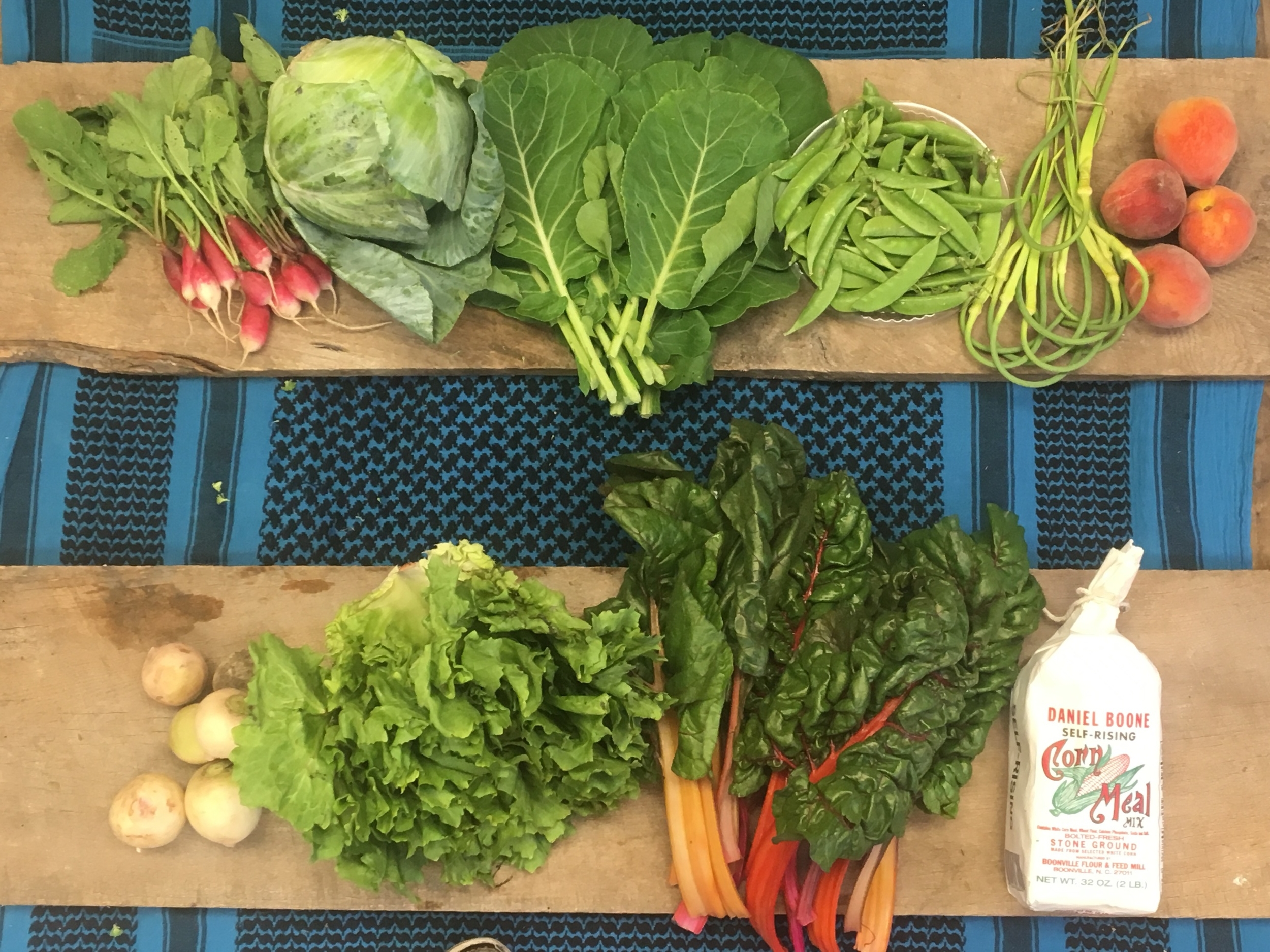 Southern Comfort Family~ French breakfast radishes, Green cabbage, Grab bag (Collards shown. Also available, borage, yellow squash, nasturtiums, dandelion greens, or greasy beans.) snap peas, garlic scapes, peaches, watermelon radishes, escarole, swiss chard, and Daniel Boone cornmeal.
