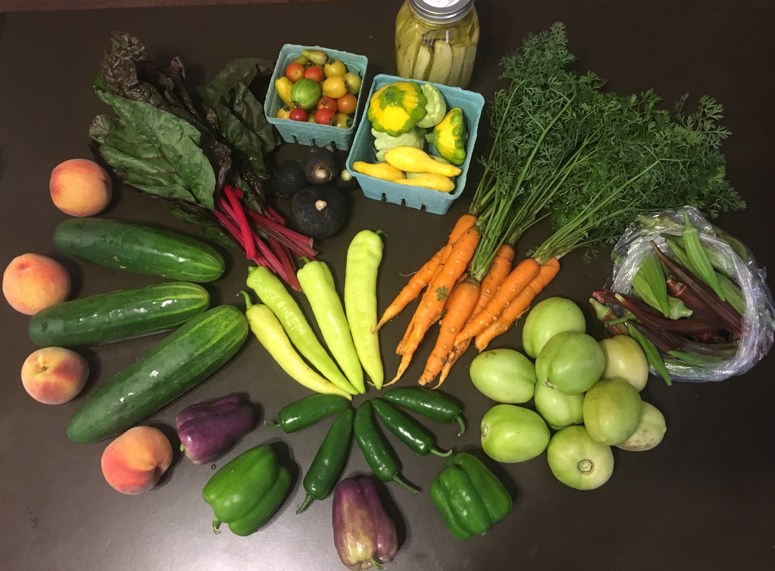  &nbsp;Peaches, slicing cucumbers, Swiss chard, black radishes, cherry tomatoes, assorted squash, pickles, carrots, okra, banana peppers, jalapeños, purple and green bell peppers, green tomatoes.&nbsp; 