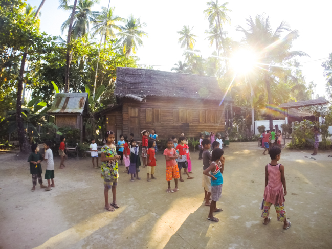 Children in front of the schoolhouse before class begins